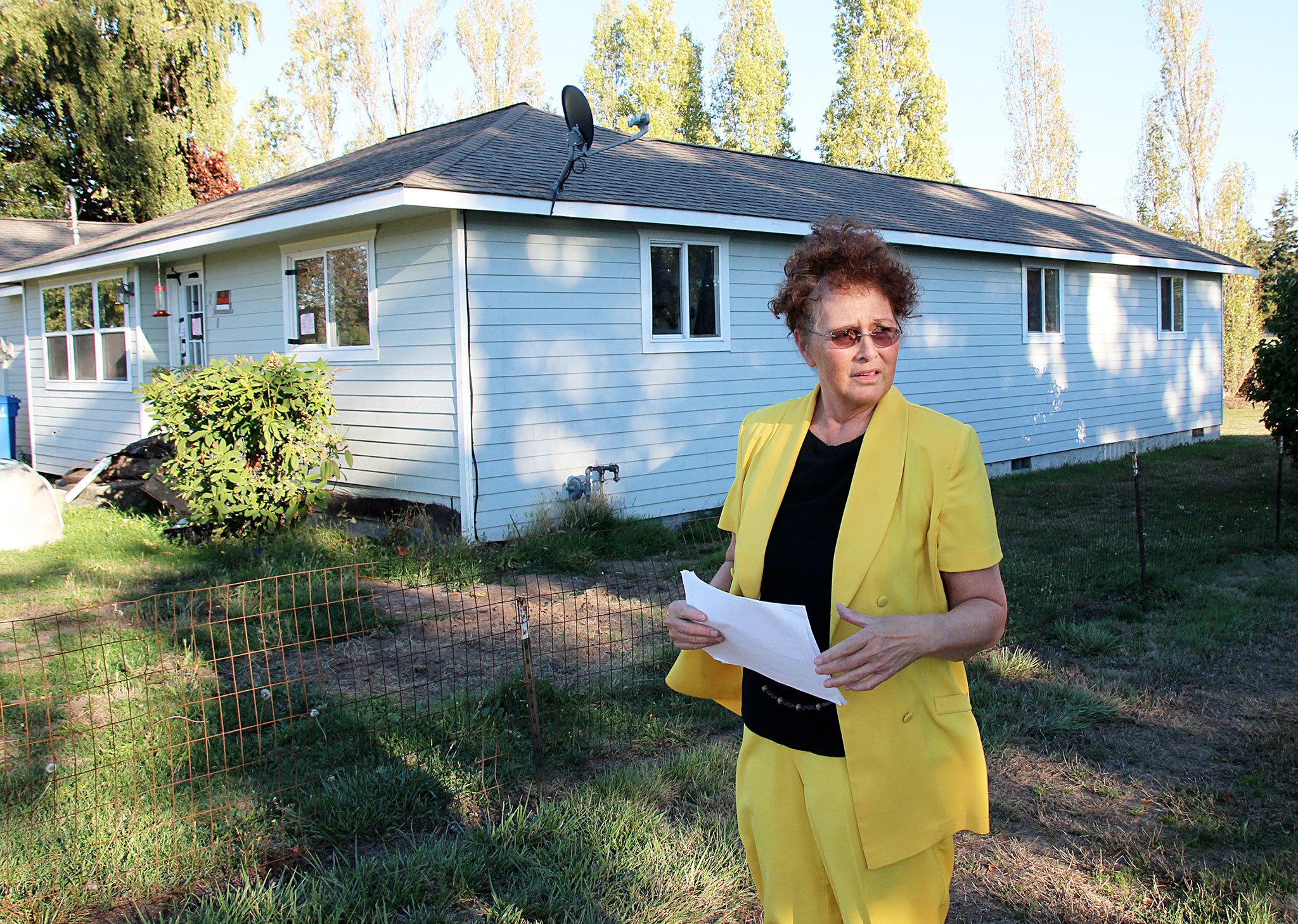 Oak Harbor resident Dee Holwitz stands in her front yard, which is next to a former nuisance house that’s been cleaned up thanks to her persistence. Photo by Jessie Stensland / Whidbey News-Times