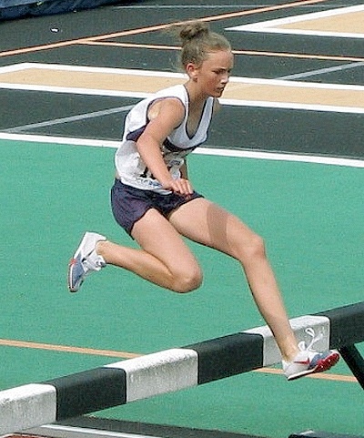 Oak Harbor’s Adrianna Royal clears a hurdle en route to victory in the 2