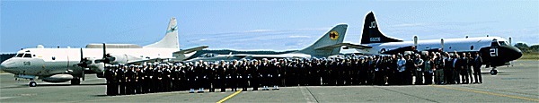 Current and former members of Fleet Air Reconnaissance Squadron (VQ) 2 gather on the tarmac for a group photo following a disestablishment ceremony for the squadron. Aircraft at rear include the EP-3 Aries at left