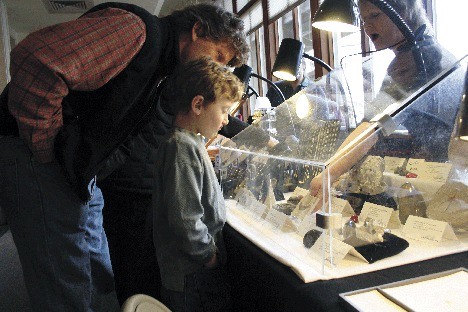 Eric Youngren and six-year-old Zane Youngren take a look at the fossil collection of Cindy McDermott and Beverly Beasley. The collection also included ammonites