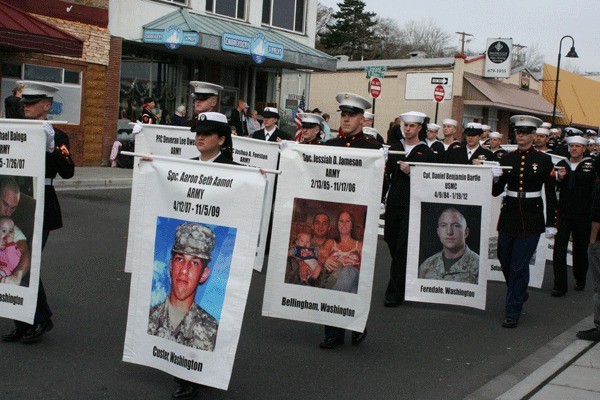 Active duty marines carry fallen hero banners at Oak Harbor’s Veterans Day parade Saturday.