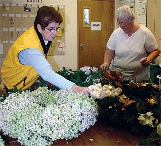 Jan Kammenga and Rosalie Ornowski decorate the holiday wreaths.