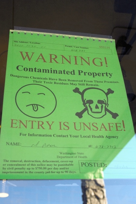 'Mr. Yuk' and other warnings are posted on the front door of the Acorn Motor Inn.