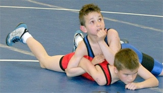 Ty Eck takes a break in an early bout and rests an elbow on the neck of his opponent