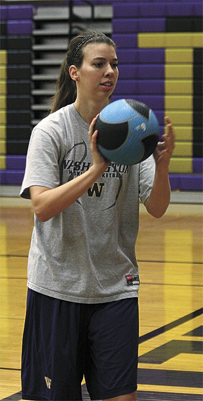 Heidi McNeill works helps with conditioning by passing a weighted basketball.