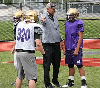 Oak Harbor High School head football coach Jay Turner explains blocking assignments at spring camp earlier this week.