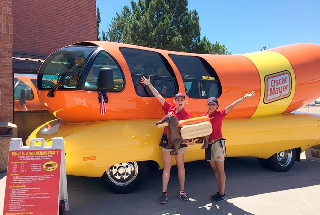 Taylor Lennox (left) and Mayra Martinez drive one of six Wienermobiles that travel throughout the United States for Oscar Mayer.