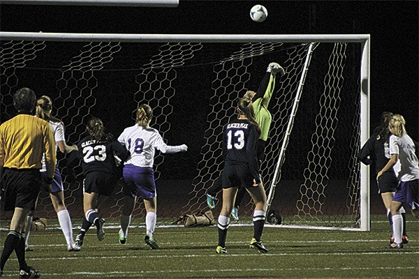 Oak Harbor goalkeeper Makenzie Perry (green jersey) deflects a shot over the goal to help the Wildcats to a 1-0 win over Glacier Peak Thursday.