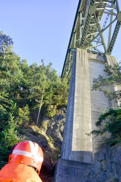 An unidentified rescuer surveys the area where a woman was found injured beneath Deception Pass Bridge this week.