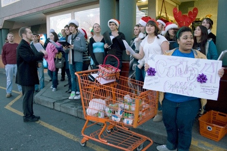 Oak Harbor High School choir students share their talents as they “Carol for Cans” outside Saars Market Place Wednesday afternoon. The event is part of an annual fundraising competition at the high school.