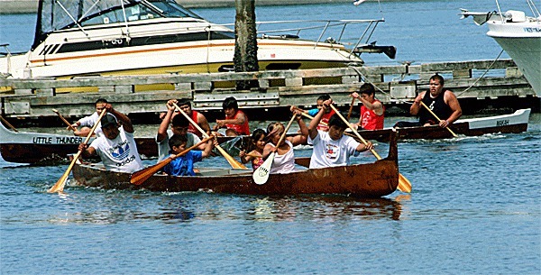 Canoe racers paddle by the Coupeville Wharf during Saturday’s Penn Cove Water Festival.