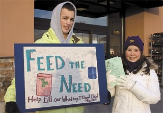 Ryan Fakkema and Kate Kapitonova advertise the food drive outside Safeway