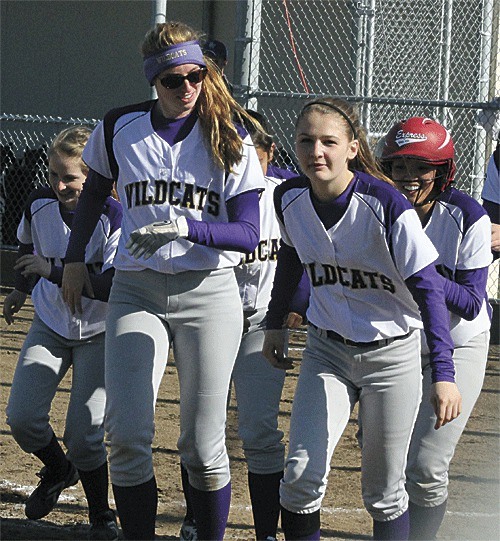 The Wildcats are all smiles as they head back to the dugout after greeting Shawna Steele (red helmet) at home plate after her home run against Shorewood.
