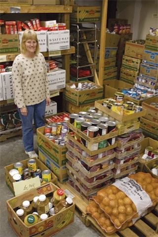 Jean Wieman stands among food donations inside the North Whidbey Help House food warehouse.
