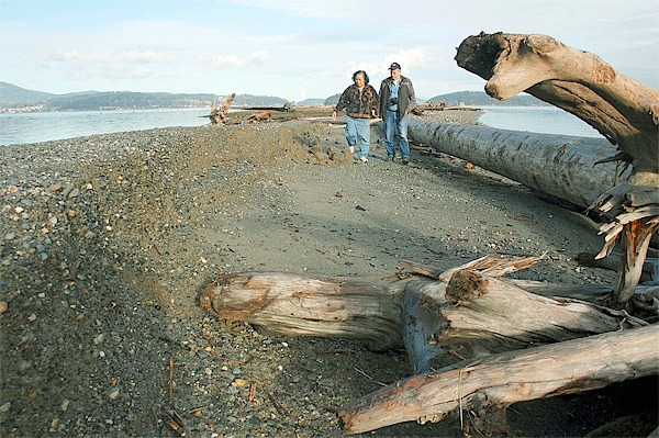 Penny Andrukat and Brian Shelly walk along a section of Ala Spit that was recently battered by waves during a high tide. They
