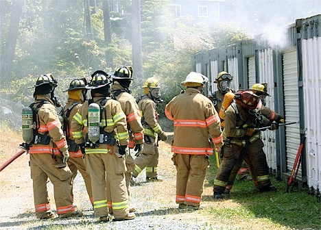 Firefighters open up a storage shed in Northgate Terrace Monday to douse a fire.