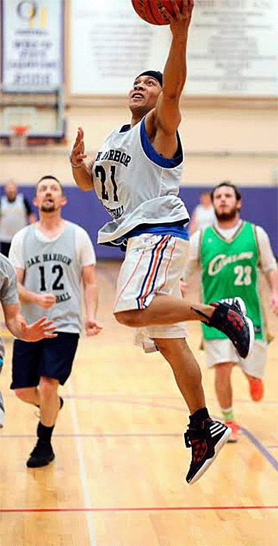 Oak Harbor High School freshman boys basketball coach Matt Nuqui scores in the annual student-staff game Friday.