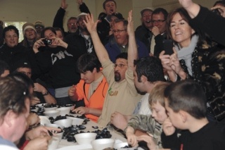 Manny Rojas raises his hands in victory as he finishes first in the mussel eating contest March 7 during the Penn Cove Mussel Festival. This is the third year that Rojas has competed in this contest.