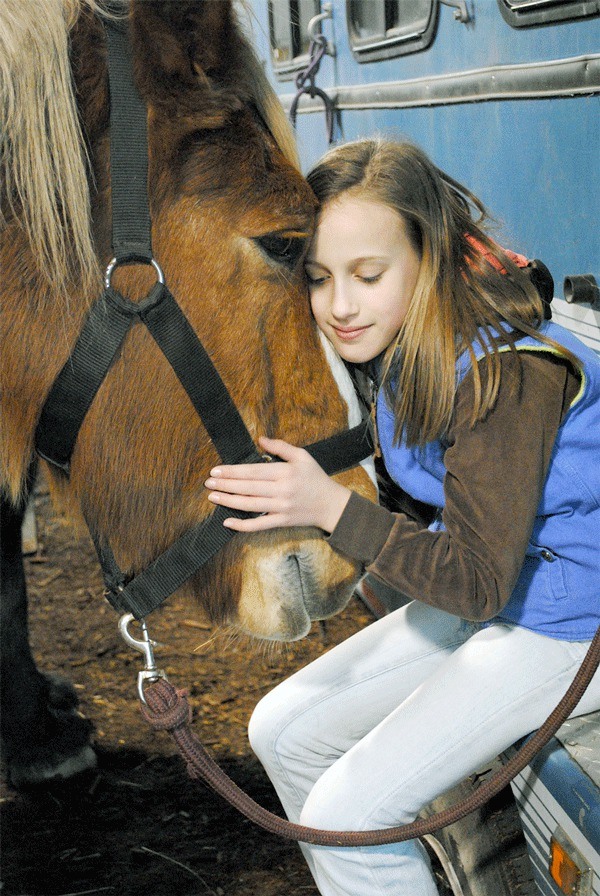 Volunteer Emily Fischer of Oak Harbor enjoys a quiet moment with Equestrian Crossings’ lovable Belgian