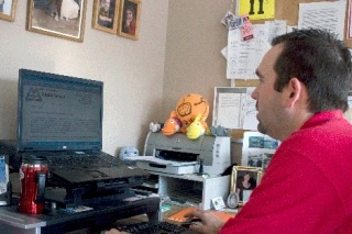 Oak Harbor Middle School Principal Shane Evans types up a letter Friday morning that was later sent home with students to notify their parents that a child contracted swine flu.