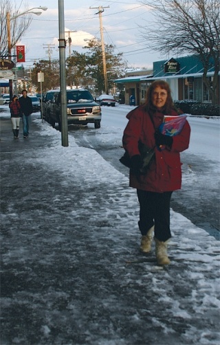 Peggy Timmins walks down Pioneer Way Thursday afternoon. Businesses were trying to stay open despite the inches of snow and freezing temperatures.