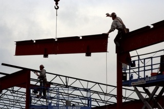 Workers from construction company Spee West lower the final steel support into place