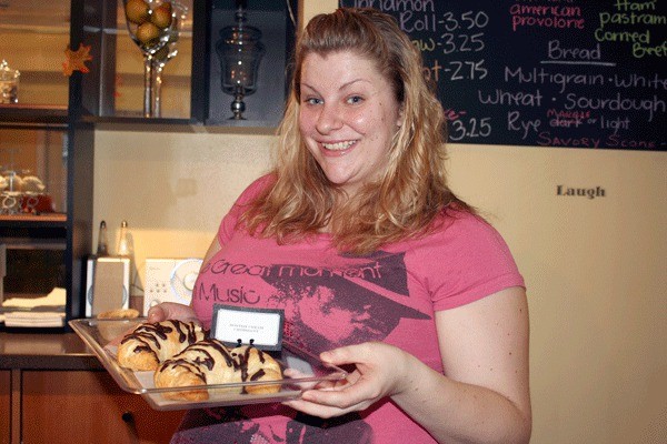 Baker Jessica Brown shows off two of her popular Boston Cream croissants at Yummies’ Eats and Treats