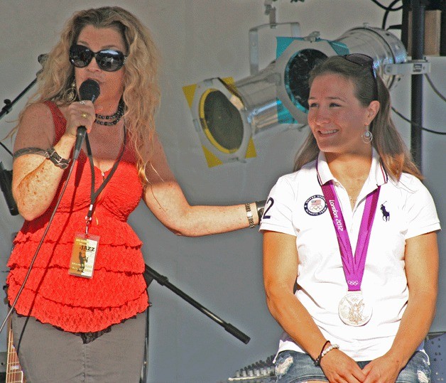 Janie Cribbs of the band Tambourine Sky sings to Olympic champion Marti Malloy at the start of the Oak Harbor Music and Jazz Festival.