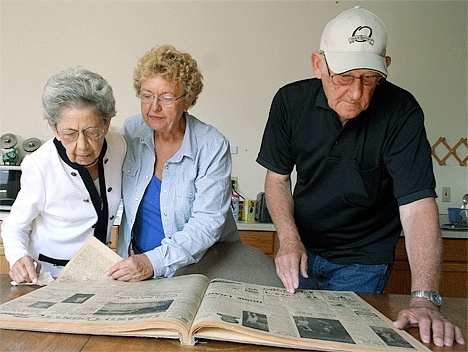 Oak Harbor Class of 1959 classmates Betty Lang Moore (center) and Jerry Storey peruse a copy of the Oak Harbor News from the year they graduated. At left is their third-grade teacher