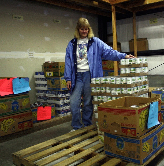North Whidbey Help House director Jean Wieman looks over a mostly empty pallet used to store food. Despite hundreds of families seeking help from the food bank