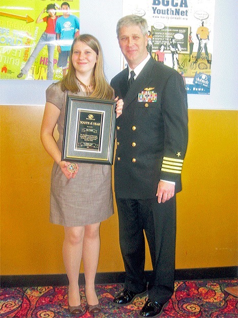 Captain Gerral David presents Amy Conner with a Youth of the Year plaque from the Whidbey Island Naval Air Station Boys and Girls Club. He also gave Conner one of his command coins.