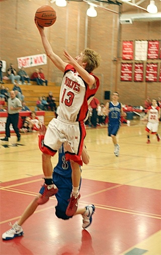 Coupeville’s J.D. Wilcox takes the ball to the basket past South Whidbey defender Riley Newman to score two of his 12 points in Tuesday’s game.