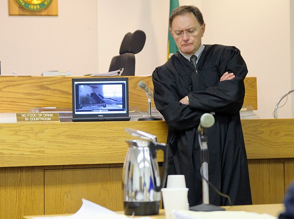 Judge Bill Hawkins listens to a recording prior to trial.