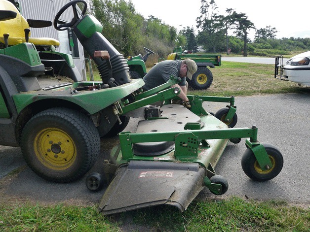 Fort Casey Park Aide Chris Bailey tends to a riding lawn mower. Washington State Parks officials are asking the state for $18 million to help pay for park operations.