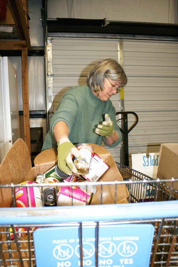 Oak Harbor resident Christy Barney stocks cans of food at the North Whidbey Help House warehouse on Southeast Hathaway Street.
