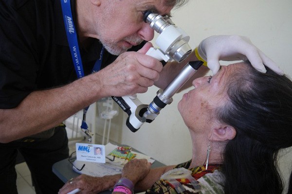 Dr. Mark Cichowski examines a patient’s eyes during a trip to Colombia.