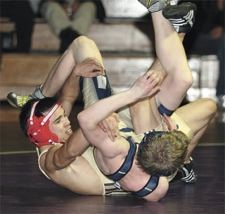 Oak Harbor’s Royce Cardwell flips his man over at 119 pounds. Cardwell won the decision.
