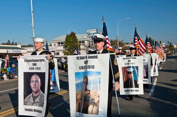 Local active duty servicemen and women carry Fallen Hero banners in last year’s Veterans Day parade in Oak Harbor.