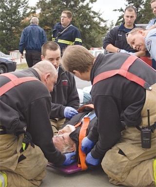 Emergency personnel secure Van Llewelyn to a back board before transporting him to Whidbey General Hospital. He was released that evening.