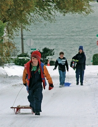 Alexander Toney pulls his sled up a hill Sunday morning in Oak Harbor. More snow blew through Whidbey Island over the weekend