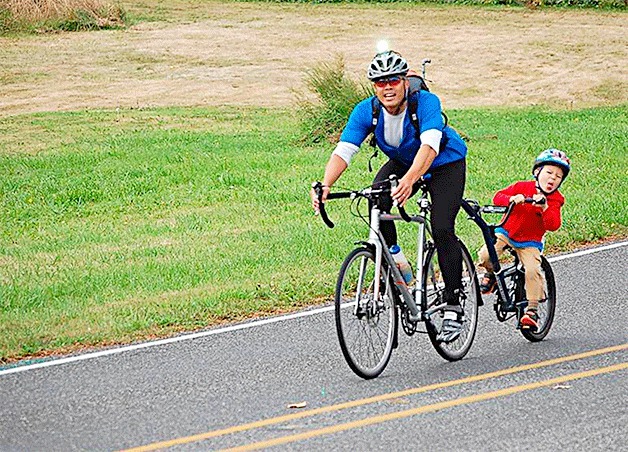 One of the youngest cyclists in the Tour de Whidbey sticks out his tongue as the former chairman of the Whidbey General Hospital’s foundation snaps a photo.