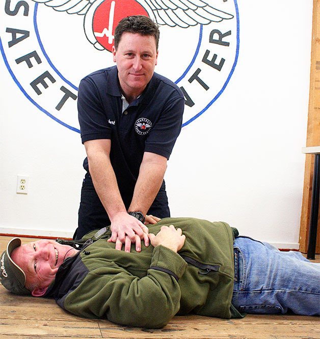Paramedic Rob May performs mock CPR on Heartbeat Safety Center’s founder Rick Stratton at their new educational center on Fidalgo Avenue.