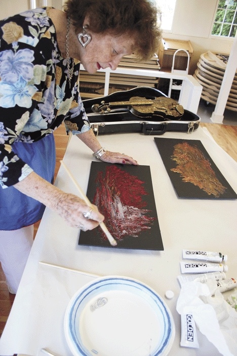 Mixed media artist Joan Brosnahan creates an art piece Friday at the Coupeville Rec Hall. Her work will be among the Whidbey Allied Artists’ group at the Coupeville Arts and Crafts Festival this weekend.