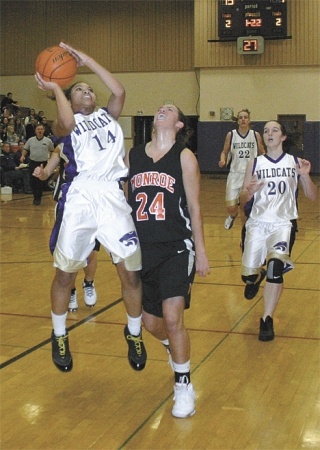 Oak Harbor’s Jessica Denmon takes the ball to the rack and draws a foul from Monroe defender Emily Drivstuen