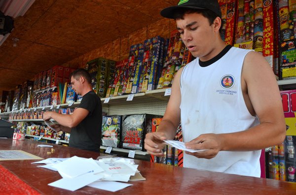 Jake Brown and Ryan Meese work to set up a Discount Fireworks stand at the old Ford dealership lot on State Highway 20 in Oak Harbor. The Island County Commissioners agreed Monday to shorten the county’s rules to comply with state law.