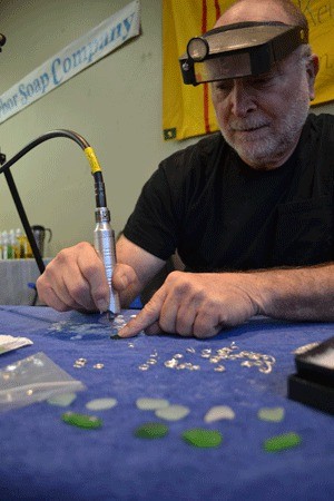 Au Sum Jewelry owner Kent Sanders makes jewelry out of beach glass at the Holiday Market.