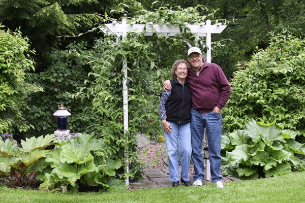 Laura and Bret Medbury stand on their 2.5-acre North Whidbey property that will be featured on the Garden Tour and Tea on Saturday