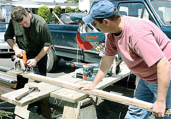 Coupeville residents Doug Kelly and Jeff Howell saw wood during the Central Whidbey Hearts and Hammers work day. The annual event saw 100 volunteers make repairs to 22 homes throughout Central Whidbey Island.