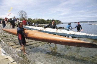 A group of pullers carry their canoes down the boat launch Saturday at Captain Coupe Park for the one-man race.