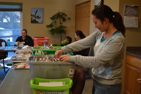 Oak Harbor resident Mayuko Jordan sorts through the box of donated coupons on Friday